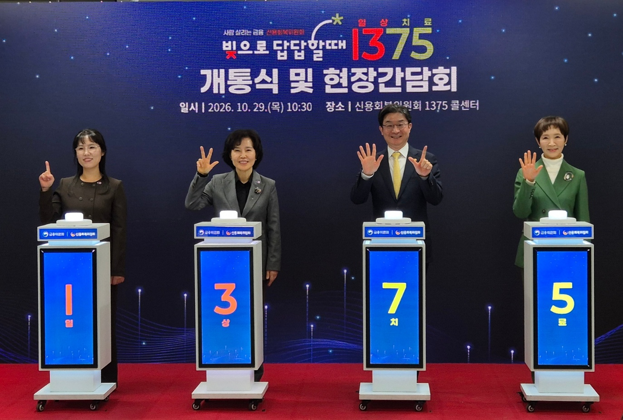 박현자(왼쪽 첫번째) 신용회복위원회 상담사, 김은경(왼쪽 두번째) 신복위장, 이억원(왼쪽 세번째) 금융위원회 위원장, 정애리 배우가 29일 오전 서울 영등포구 신복위 콜센터에서 손으로 전화번호 ‘1375’를 만들어 보이고 있다. [신용회복위원회]