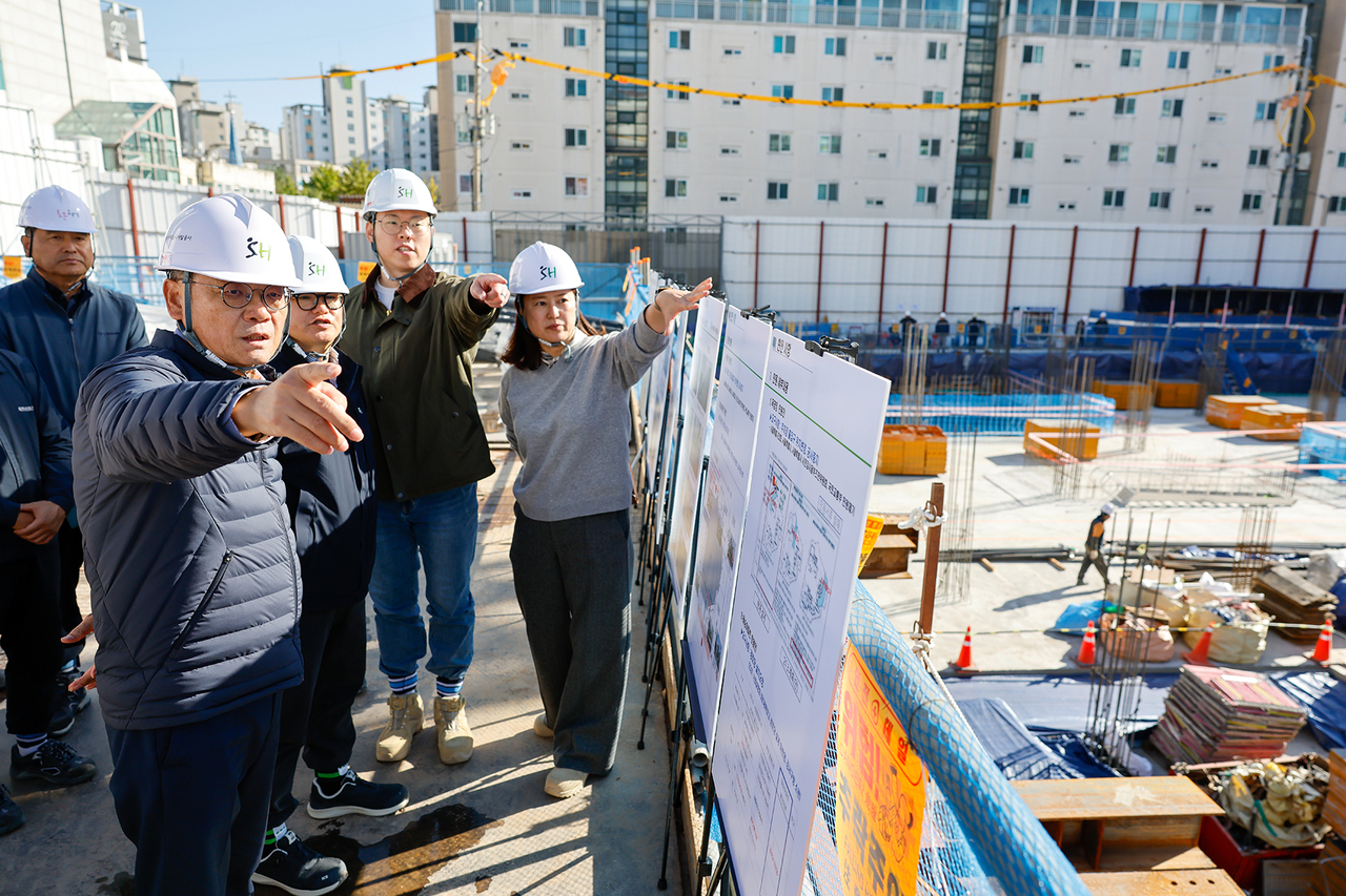 Hwang Sang-ha (first from left) and an inspection team review the construction site of the Magok-dong 1410 public housing project. [SH]