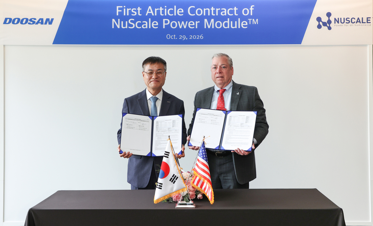 NuScale Power Chief Operating Officer Carl Fischer (right) and Doosan Enerbility Nuclear Business Group President Kim Jong-du pose for a photo at a contract signing ceremony held Thursday at Doosan Enerbility's headquarters in Changwon. [Doosan Enerbility]