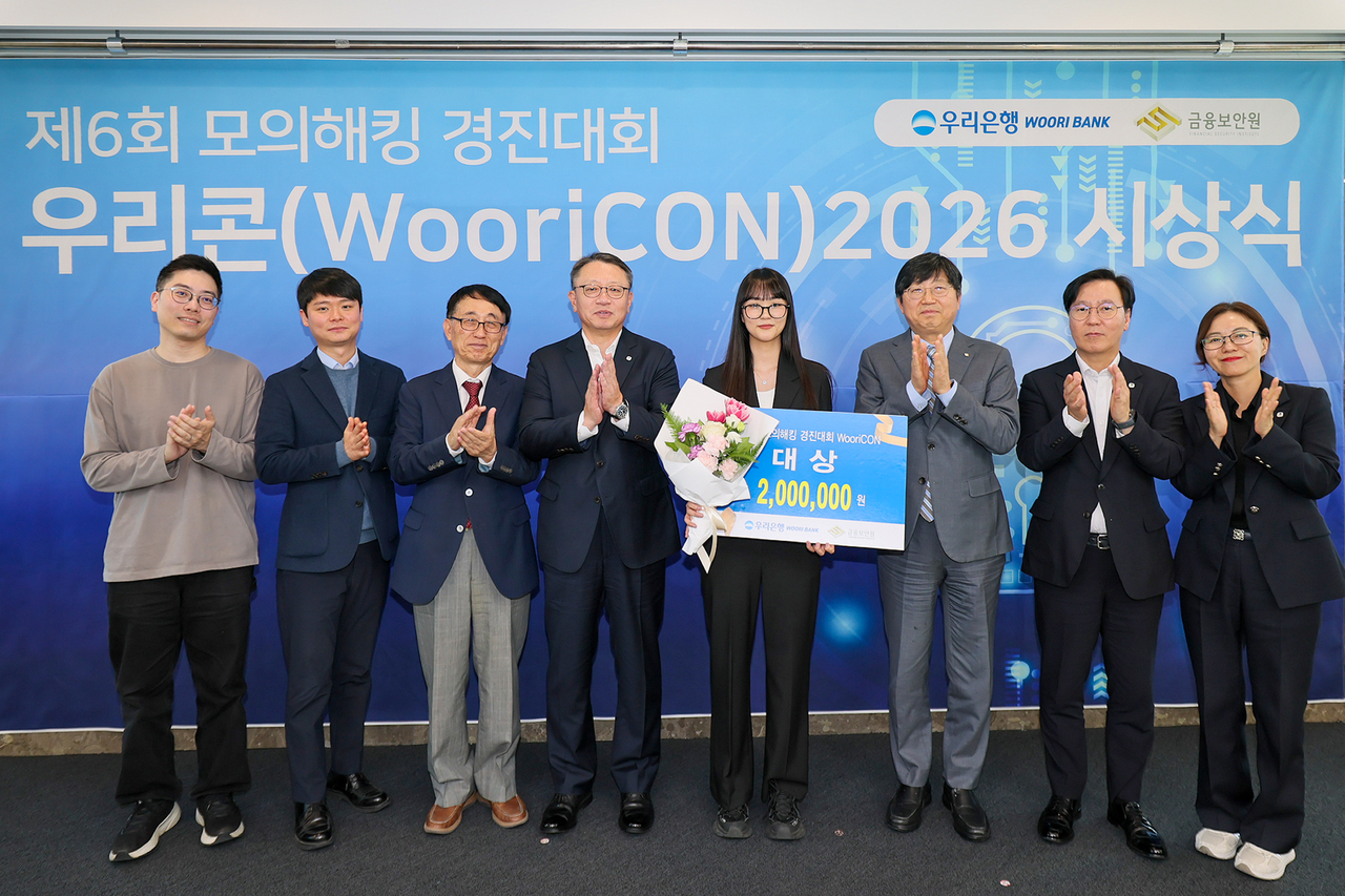 Woori Bank President Jeong Jin-wan (fourth from left), grand prize winner Kim Hyun-ju of Catholic University, Financial Security Institute President Park Sang-won, and judges and Woori Bank officials pose for a photo at the sixth WooriCON mock hacking competition awards ceremony, held Wednesday at Woori Bank's headquarters in Jung-gu, Seoul. [Woori Bank]