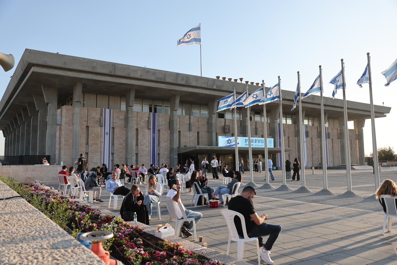 People sit outside the Israeli parliament Knesset in Jerusalem, Wednesday. (EPA-Yonhap)
