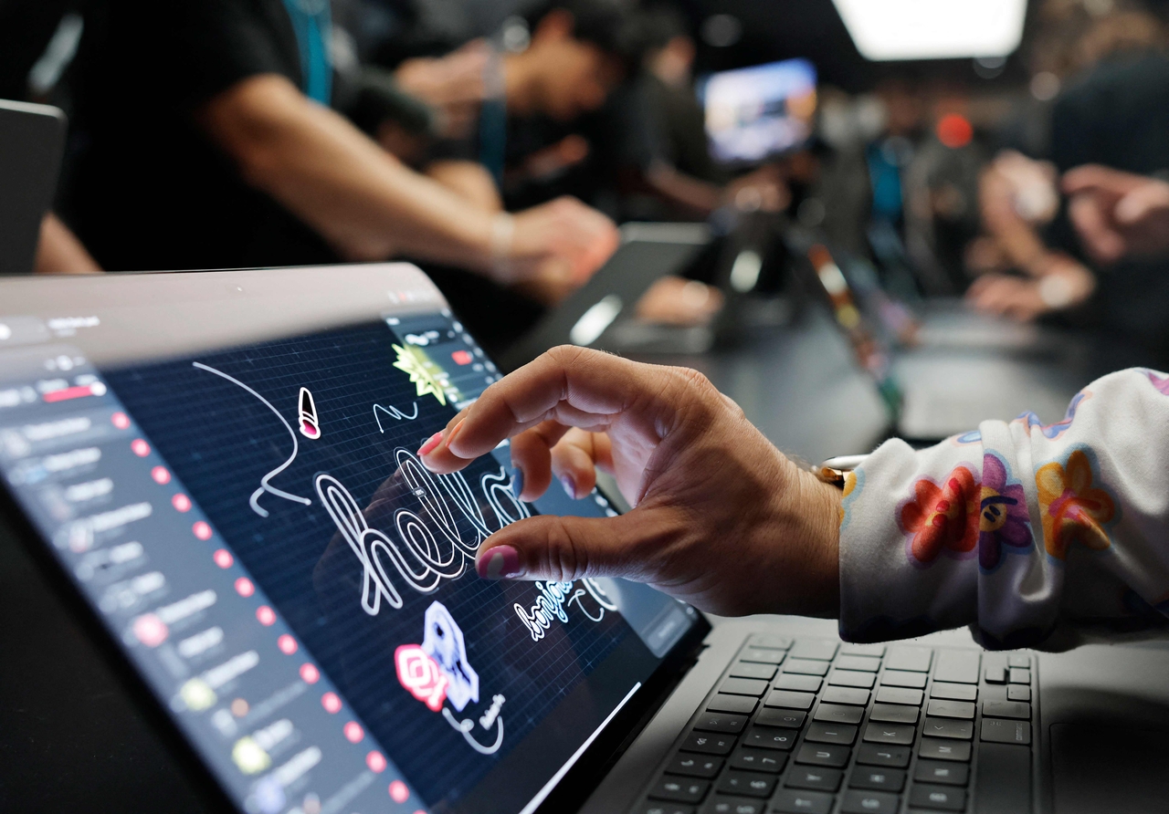 People try out the new touchscreen MacBook Pro at an event in Los Angeles on Wednesday. (AFP-Yonhap)