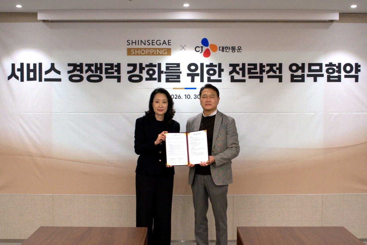 Han Hye-rim (left), executive director of support at Shinsegae Live Shopping, and Yoon Jae-seung, head of CJ Logistics' O-NE division, pose for a photo at the MOU signing ceremony held Friday at Shinsegae Live Shopping's headquarters in Seongsu-dong, Seoul. [Shinsegae Live Shopping]
