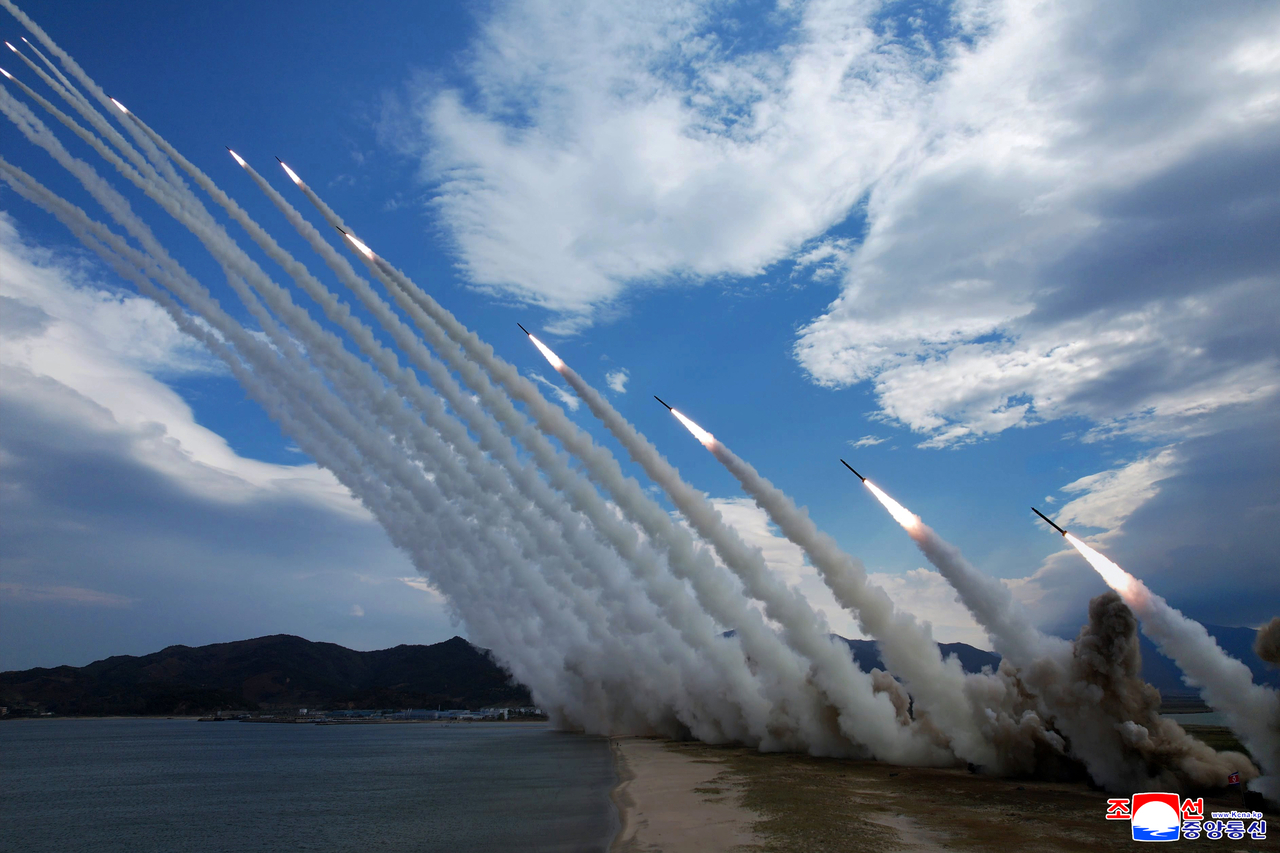 Rockets streak across the sky during the first firing of North Korea’s 600 mm multiple rocket launcher system dubbed “Sniper,” observed by leader Kim Jong-un on Thursday, in this photo released by the Korean Central News Agency on Friday. (Yonhap