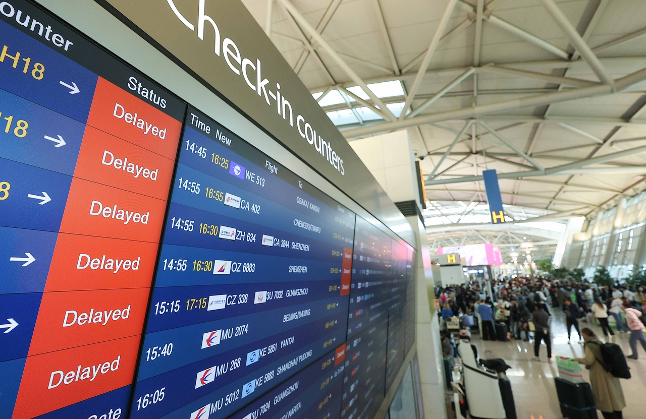 Departure and arrival boards show flight delays at Incheon International Airport’s Terminal 1 on Friday. (Yonhap)