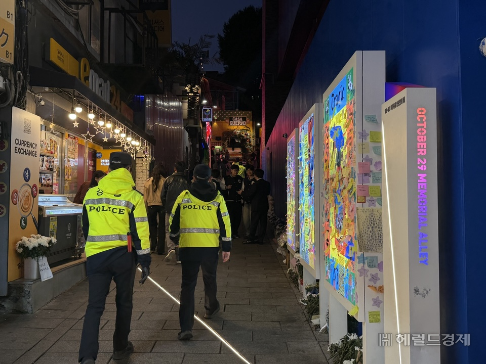 Police officers patrol an alleyway near Itaewon Station in Yongsan-gu, Seoul, around 6 p.m. Friday. (Jeon Sae-nal)