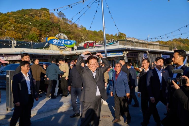 President Lee Jae-myung greets residents at Yeongyang Traditional Market in North Gyeongsang Province on Saturday. [Cheong Wa Dae]