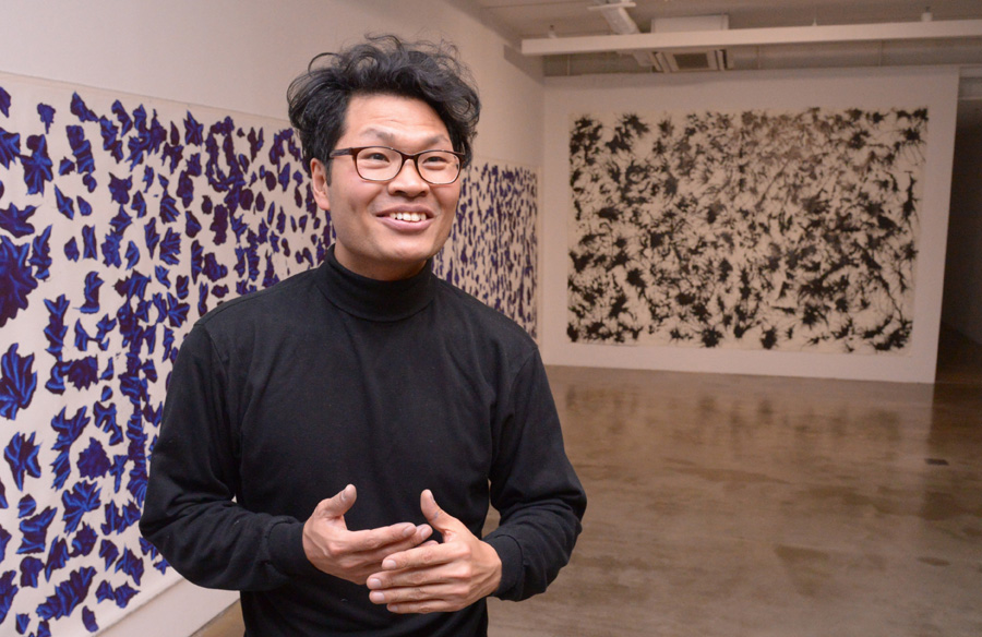 Artist Choi Sun speaks in front of his painting “Butterflies” on March 6 at Songeun Art Space in Seoul. (Chung Hee-cho/The Korea Herald)