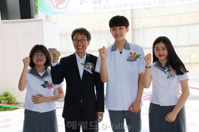 이훈 국회의원과 대표 학생이 기념촬영을 하고 있다.