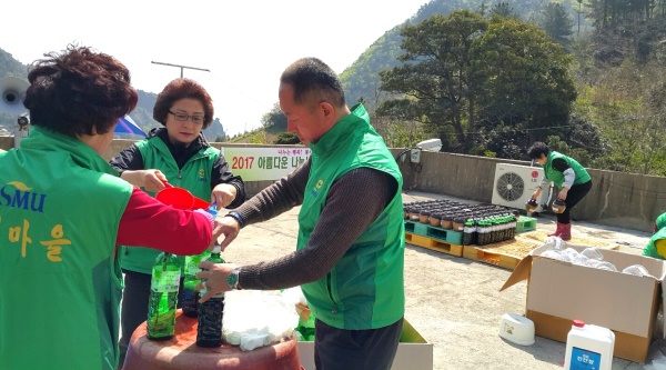 전통  장담그기 행사에 새마을 지도자 까지 동원돼 용기에 간장을 넣는 작업을 진행하고 있다.(새마을 지회 제공)