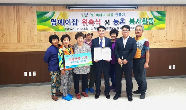 김창선(오른쪽 세번째) 울릉군 지부장이  명예이장으로 위촉된후 이태숙(왼쪽 세번째)마을이장에게 생활용품 50만원 상당을 기증한후 기념촬영을 하고 있다.(농협제공)