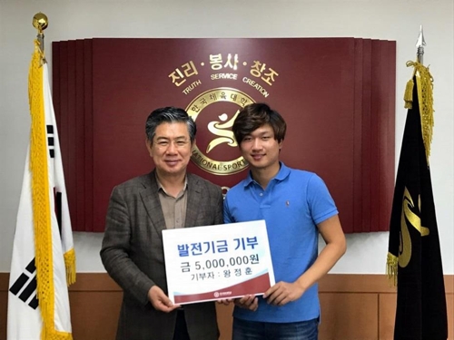 왕정훈이 21일 한체대를 찾아 발전기금을 전달했다. 왼쪽은 김성조 한체대 총장. [사진=한체대]
