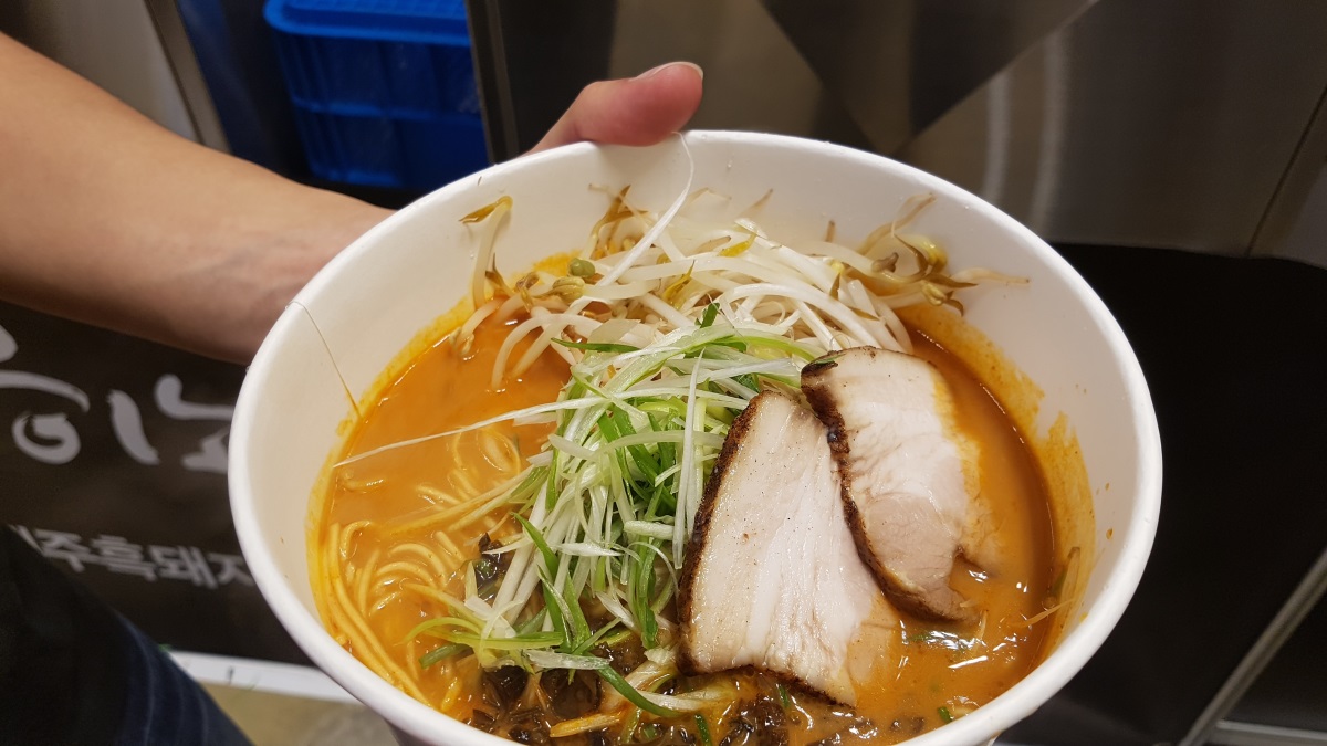 A visitor holds a bowl of Japanese ramen at the Ramen Fair at Coex on Sunday. (Rumy Doo/The Korea Herald)