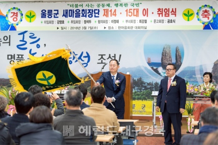15대회장으로 취임한 정석두 회장이 새마을기를 이양받아 흔들고 있다.(울릉군 새마을회 제공)