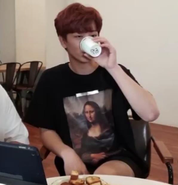 (Yook Sungjae drinks from a cup with the words "do not feed (the trolls)" on the bottom. Photo credit: Naver's V Live)