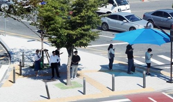 햇빛을 피해 그늘로 몸을 숨긴 시민들(사진=연합뉴스)
