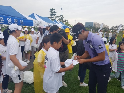신한금융 소속 장이근 선수가 스내그골프를 마친 어린이들에게 사인을 해주고 있다.