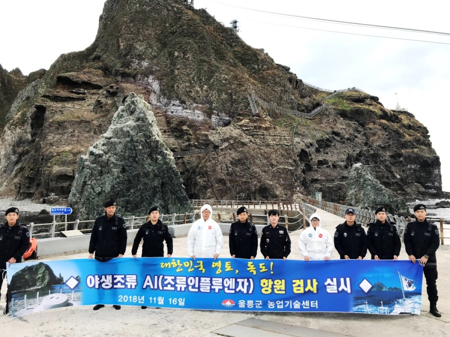 지난 16일 독도현지에서  조류인플루엔자(AI) 항원검사에 나선 울릉군 농업기술센터 동물방역 요원들이 동도 선착장에서 독도경비대원들과 기념촬영을 하고 있다(울릉군 제공)