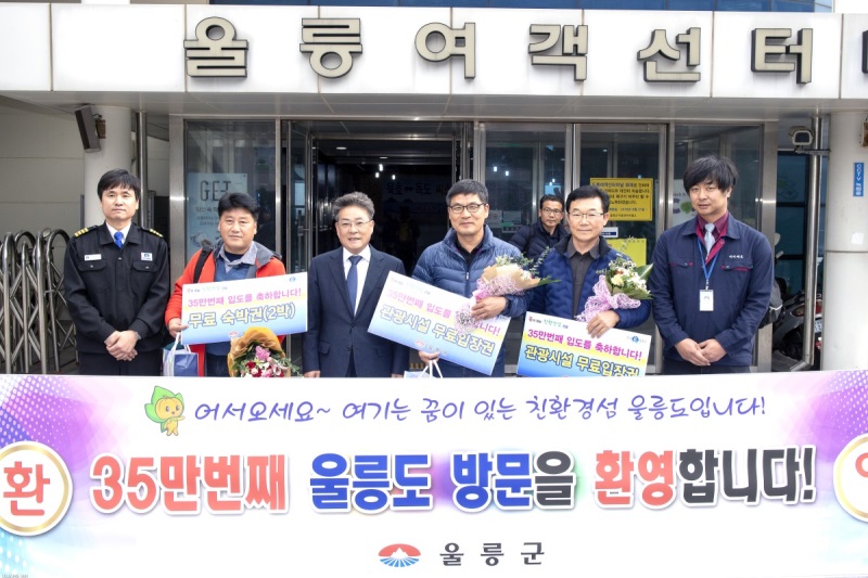 울릉군이 35만명의  관광객이 재돌파 하자 이벤트를 진행, 꽃다발과 기념품을 전달한후 기념촬영을 하고 있다.(울릉군 제공)
