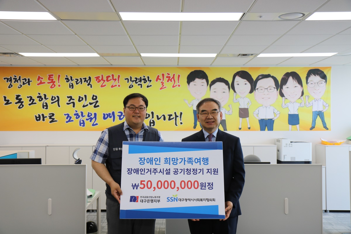 김정원 대구은행 노조위원장(왼쪽)이 이재모 대구시사회복지협의회장에게 장애인 후원금을 전한 뒤 기념촬영을 하고 있다.(대구시사회복지협의회 제공)