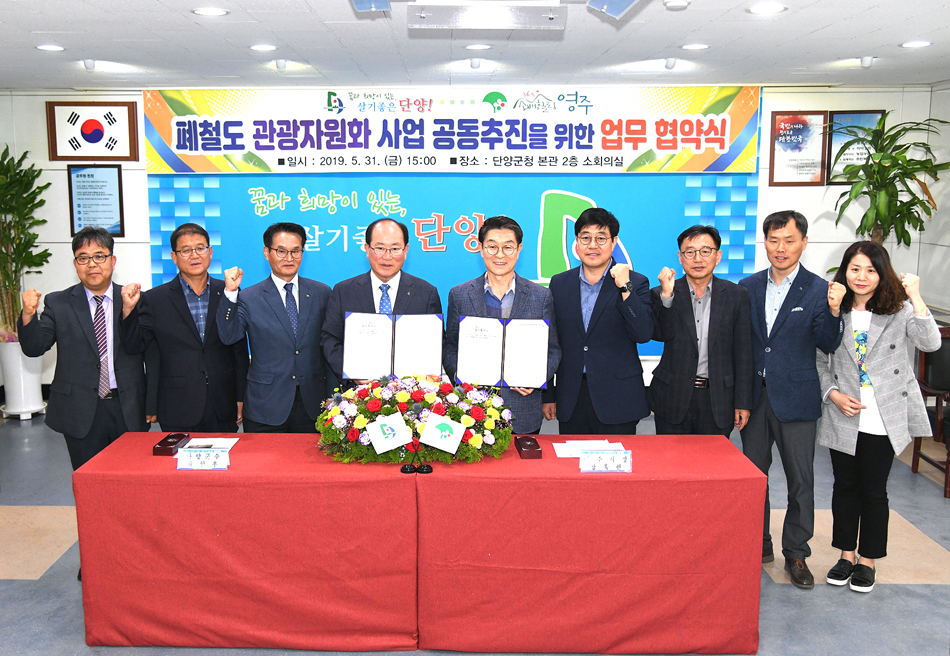 31일 류한우(왼쪽네번째) 충북 단양군수와 장욱현(다섯번째) 경북 영주시장이 단양군청 회의실에서 '폐철도 관광자원화사업 공동추진을 위한 업무협약'을 체결하고 양도시 관계자들과 함께 기념사진을 찍고 있다.(영주시 제공)