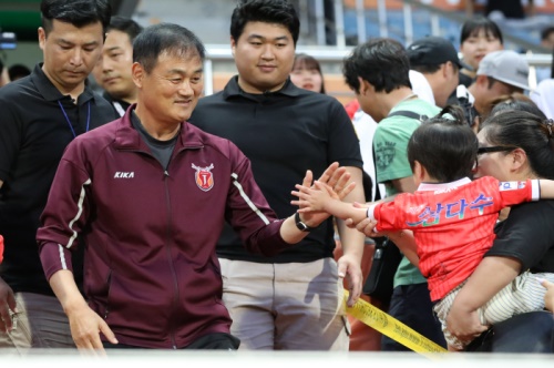 제주의 최윤겸 감독이 지난 울산과의 K리그 24라운드 경기를 앞두고 어린이 팬과 하이파이브를 하고 있다. [사진=제주유나이티드]