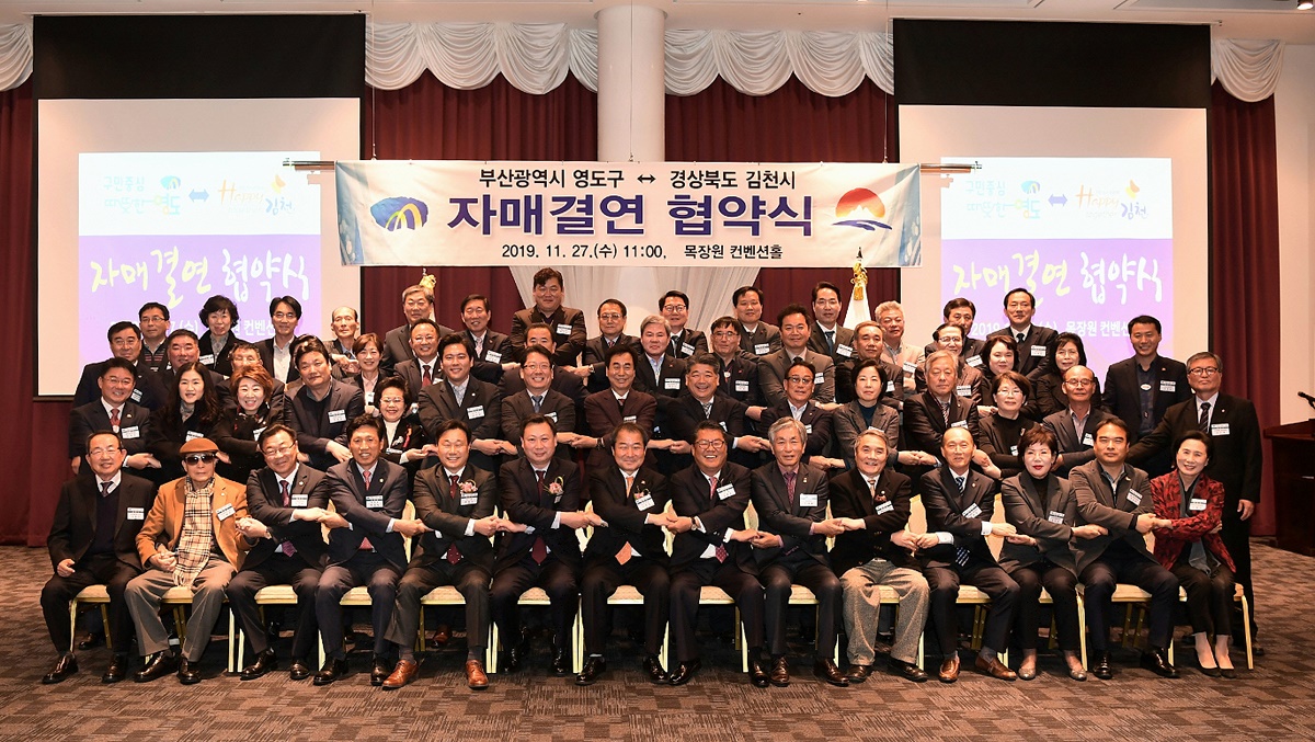 27일 부산 목장원 컨벤션홀에서 열린 김천시와 부산 영도구 자매결연 협약식에사 양 기관 관계자 들이 두손을 맞잡고 상생협력을 약속하고 있다(김천시 제공)