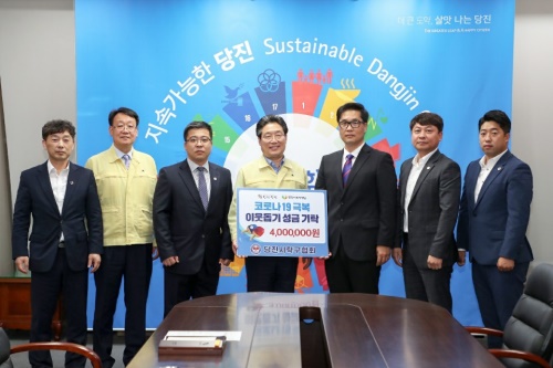 지난 1일 권세용 당진탁구협회장(오른쪽 3번째)이 김홍장 당진시장(가운데)에게 코로나19 극복 이웃돕기 성금을 전달했다. [사진=당진시탁구협회]