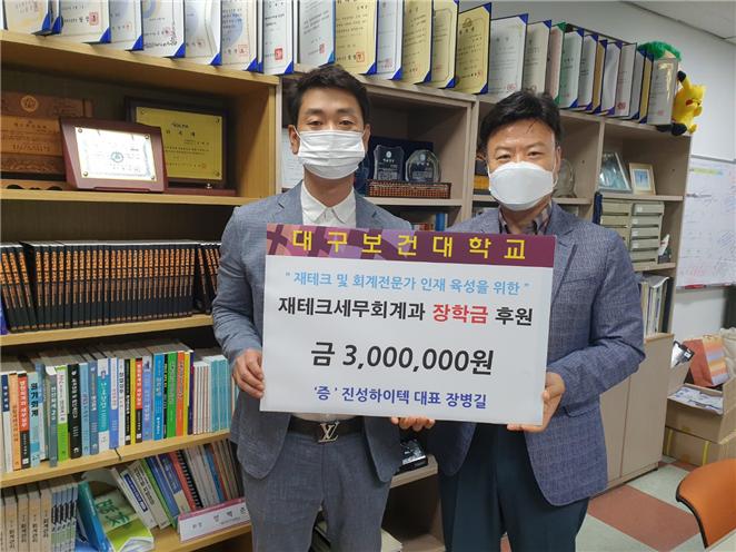 장병길 대표(왼쪽)가 성백춘 교수에게 장학금을 전달, 기념촬영을 하고 있다.[대구보건대 제공]