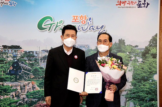 이강덕 포항시장( 왼쪽)이 김종식 전 일자리경제실장에게 경제특보 위촉장을 전달하고  기념사진을 찍고 있다(포항시 제공)