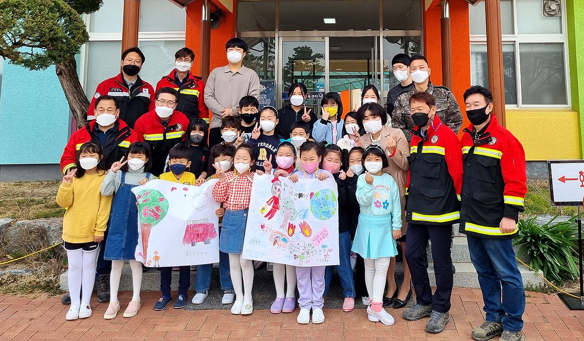 봉화 산골 도촌 초등학교 1~4학년 학생들이 교정에서 소방관들과 기념사진을 찍고 있다(봉화군 제공)