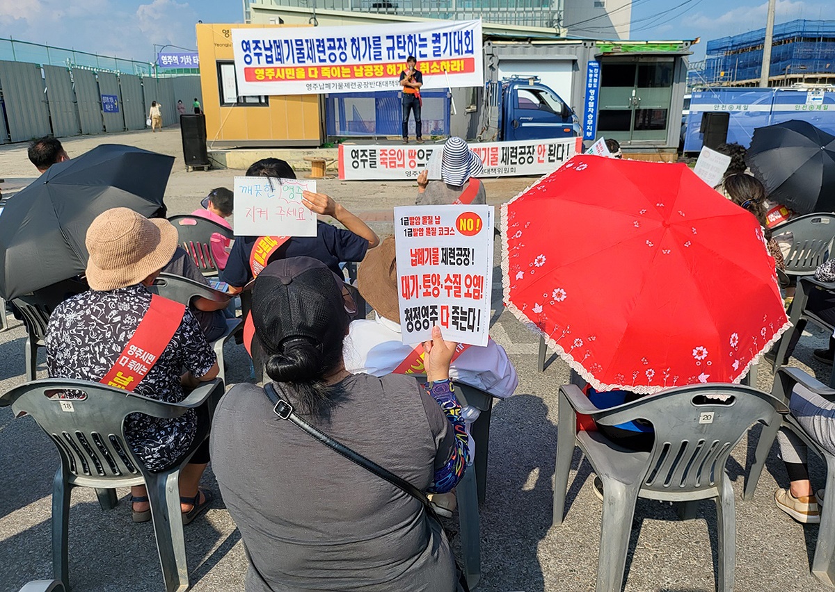 영주역 광장에서 열린 납 폐기물 제련공장 허가에 대한 규탄대회에 참석한 한 시민이 '납폐기물 제련공장 청정영주 다죽는다'라는 손 펫말을 들고 있다(사진=김성권 기자)