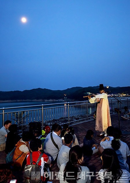 안동달빛투어 '달그락'에서 참가자들이 월영교에서 진행된 대금 연주를 감상하고 있다