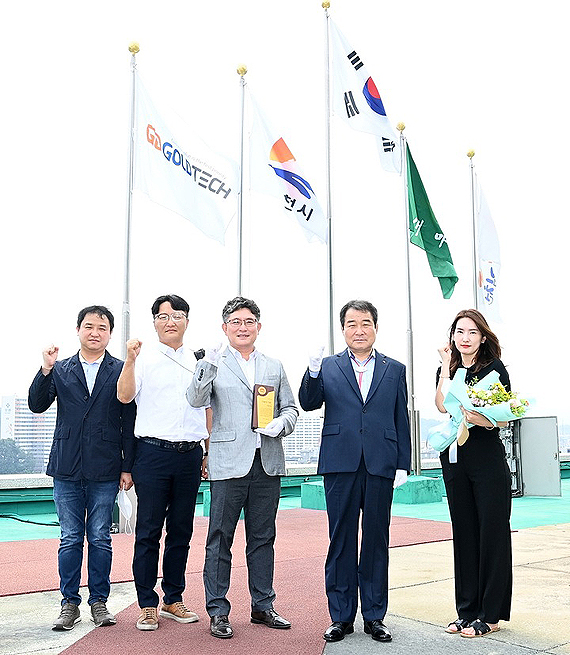 7월 '이달의 기업'에  선정된 ㈜골드테크 관계자와 김충섭 시장이 회사기를 게양한후 기념사진을 찍고 있다(김천시 제공)