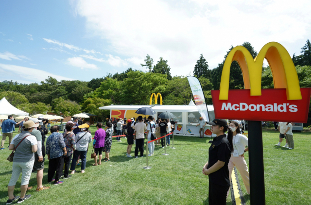 지난 14일 오후 2시 전남 보성 한국차문화공원 잔디광장에서 보성 주민들이 맥도날드의 보성 녹돈 버거를 맛보기 위해 줄을 서 있다. [한국맥도날드 제공]