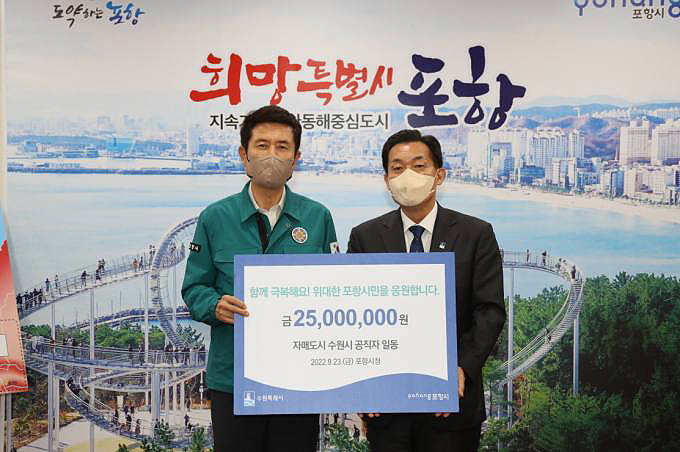 이재준 수원시장(오른쪽)이 이강덕 포항시장에게 성금을 전달한 뒤 기념사진을 찍고 있다. (포항시 제공