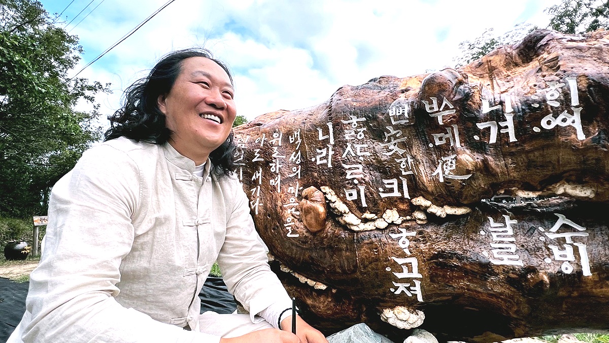 완성된 훈민정음해례본 108자 앞에서 활짝웃는  진성영 작가(작가제공)