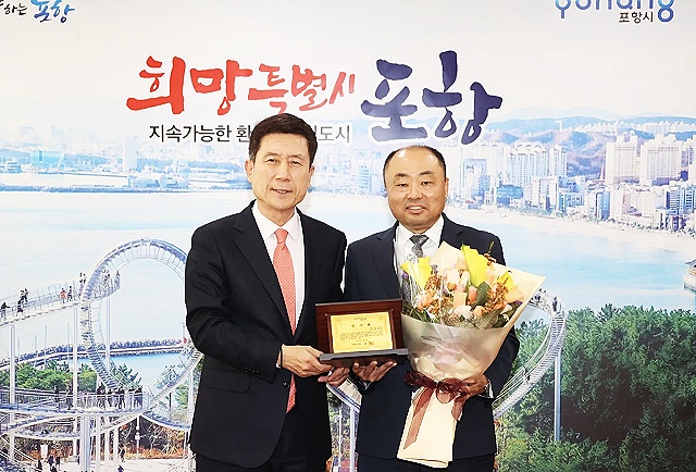 최병욱 국토교통부노동조합 위원장(오른쪽)이 지난  24일 포항시 감사패를 받고 이강덕 포항시장과 기념사진을 찍고 있다. (국토부노조 제공)