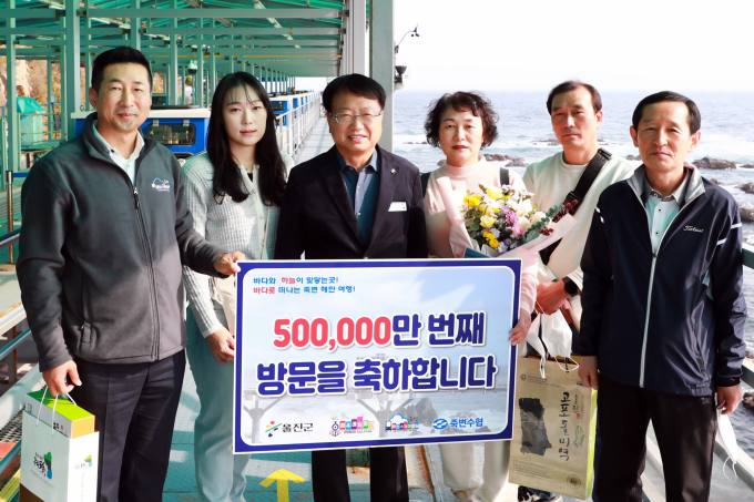 손병복 울진군수(왼쪽 세번째)가 50만번째 이용객 가족들에게 축하선물을 전달한후  기념촬영을 하고 있다(울진군 제공)