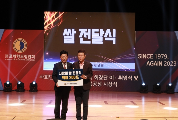 취임식을 축하하는 화환 대신 쌀을 받은 박용선 회장이 어려운 이웃들을 위해  사랑의 쌀 200포를 이강덕 포항시장에게 전달하고 있다(포항향토청년회제공)
