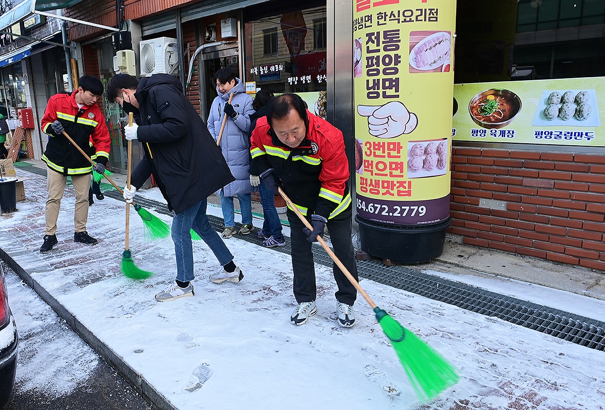 박현국 군수등 직원들이 인도변에  눈을 치우고 있다(봉화구 제공)