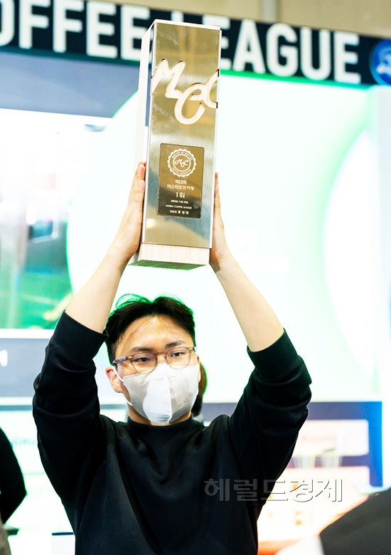 제12회 마스터 오브 커핑경연대회에서 최종우승을 차지한 최제민씨가  우승컵을 번쩍 들고 있다(독자제공)