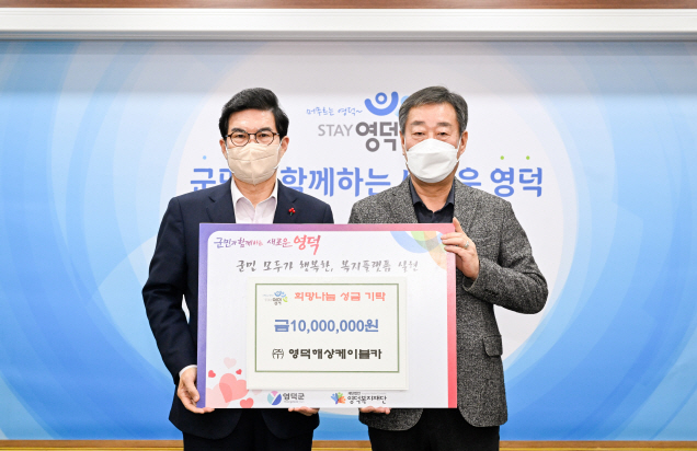 노성모 영덕해상케이블카 회장(오른쪽)이 김광열 군수에게 성금을 전달하고 있다.[영덕군 제공]