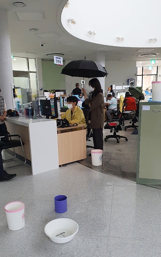 지난 2022년 10월 4일 경북 울진군 죽변면사무소가 개청(開廳) 닷새만에 심각한 누수사고가 일어나 직원들과 민원들이 우산을 쓰고 업무를 보고 있다.(울진군 제공)