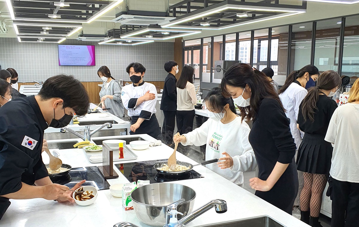 영진전문대에 재학 중인 외국인 유학생들이 내국인 학생들의 도움을 받으며 K-푸드인 한식 체험에 나서고 있다.[영진전문대 제공]