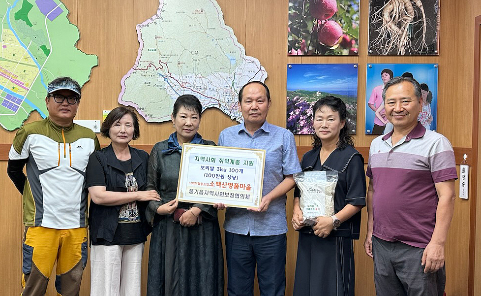 남옥선소백산명품마을 사회적협동조합 대표(왼쪽세번째)가 강 한원 풍기읍장에게 직접키워 수확한 햇 보리쌀을 전달하고 있다(소백산 명품마을 사회적협동조합 제공)