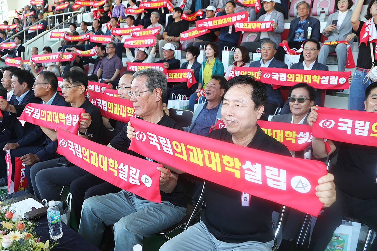 9일 열린 제63회 안동시민체육대축전행사에서 권기창 안동시장과 각급 기관단체장 시민들이 핸드 배너를 들고 의대 유치를 염원하는 구호를 외치며 국립의과대학 설립 퍼포먼스를 펼치고 있다(안동시 제공)