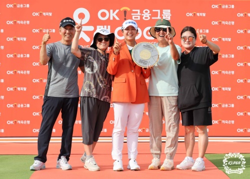 우승 트로피를 들고 가족과 함께 포즈를 취한 마다솜(가운데). [사진=KLPGA]