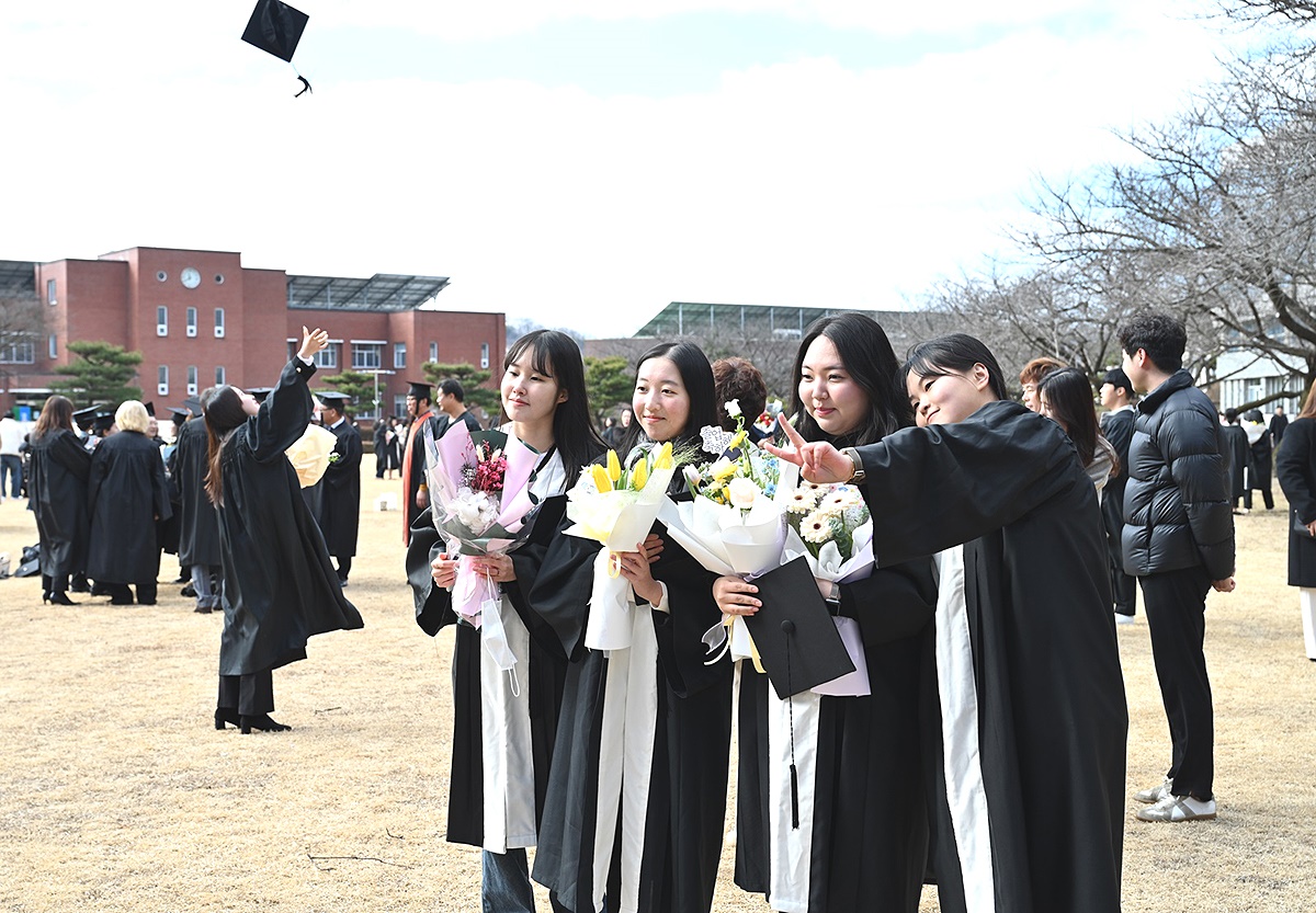 16일경북 전문대가  본교 대강당에서 ‘제51회 학위수여식’을 가졌다. 한 졸업생이 학사모를 하늘로 올리고 있으며 다른 졸업생은 기념사진을 찍고있다(경북 전문대 제공)
