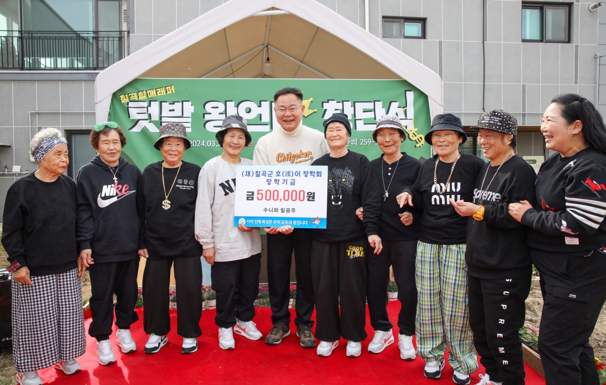 할매래퍼그룹 '수니와 칠공주' 할머니들이 김재욱 군수에게 장학금을 전달하고 있다.[칠곡군 제공]